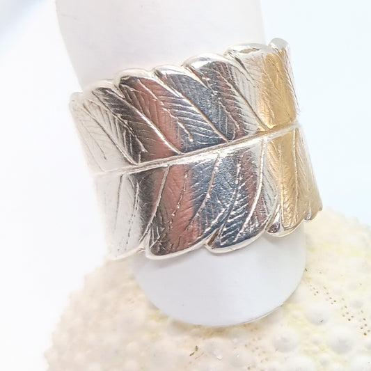 delicate veins of the fern leaf are visible on a life sized sterling silver ring cast from mother nature