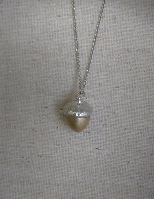 close up of closed acorn locket showing detail of acorn cap hanging on a silver chain