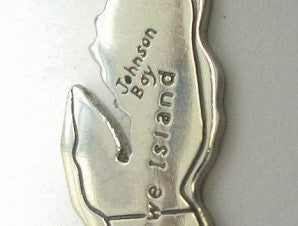 close up detail of hand lettering "Johnson Bay" and "Howe Island" across the pendant