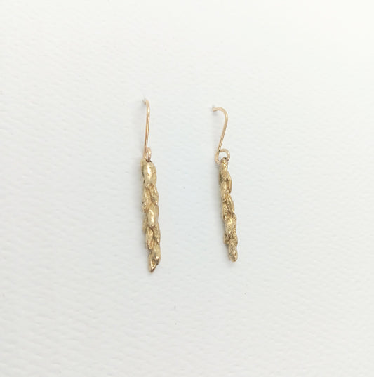 detail of 5 rows of wheat kernels are visible on a small stalk of the shiny bronze cast earrings on gold wire hooks