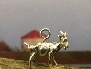 A tiny silver goat stands ready to be hung from a chain